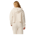 Back view of a woman wearing a cream Rip Curl Cala Nights textured cropped hoodie with a hood.