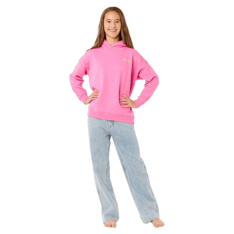 Girl wearing a bright pink Rip Curl Surf Puff Heritage Hoodie and light blue jeans.