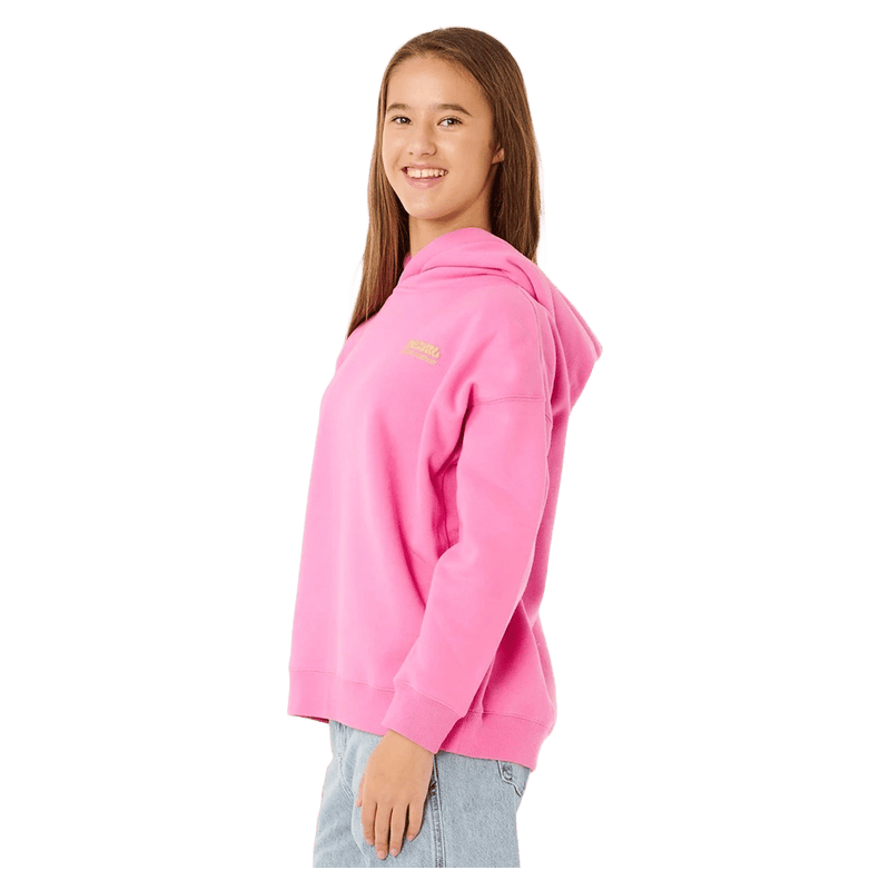 Side profile of a girl wearing a bright pink Rip Curl Surf Puff Heritage hoodie with a small yellow chest logo.