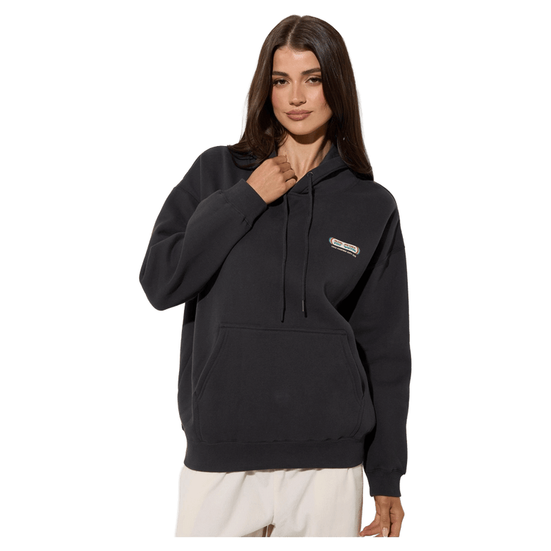 Woman wearing a charcoal Rip Curl Surf Revival Heritage Hoodie with a drawstring hood and front kangaroo pocket.