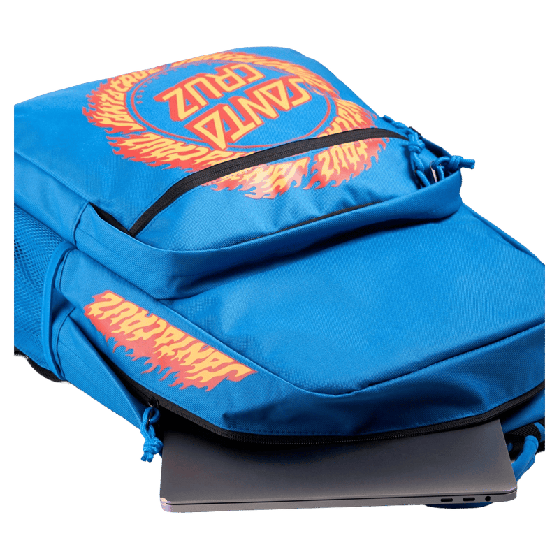 Blue Santa Cruz kids backpack with orange flame logo graphics and a laptop partially inside the main compartment.
