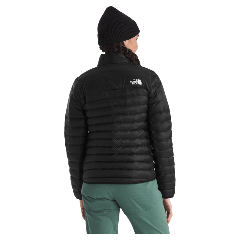 Rear view of a woman wearing The North Face Terra Peak Jacket for Women in Black featuring a short stand collar and a heat transfer white logo on the left shoulder