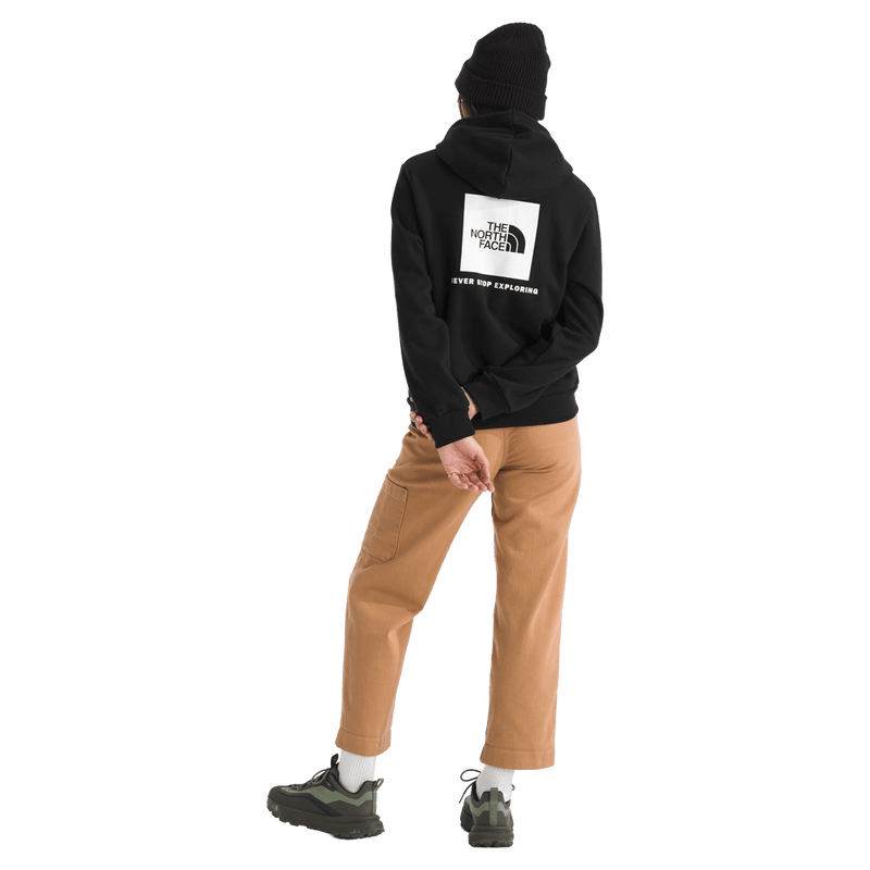 Rear view of a woman wearing The North Face Evolution Box NSE Hoodie for Women in Black featuring a box logo graphic in white and black.