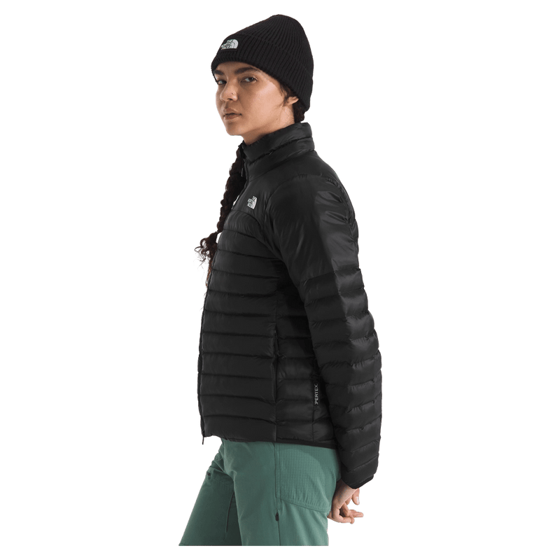 View of a woman wearing The North Face Terra Peak Jacket for Women in Black featuring a full front two-way zip with internal draft flap, zip side pockets, and a heat transfer white logo on the left chest