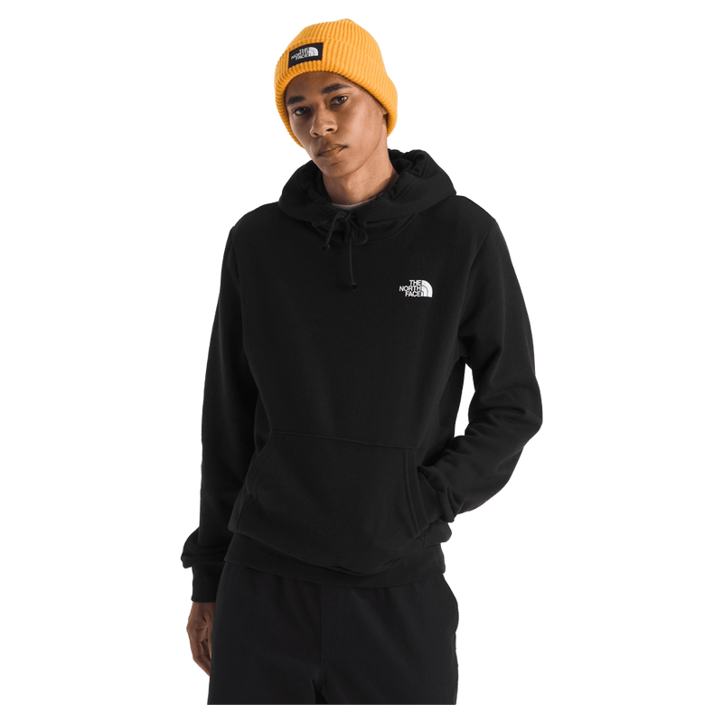 View of a man wearing The North Face Evolution Box NSE Hoodie in Black featuring an adjustable hood, kangaroo pocket and small white logo on the left chest.