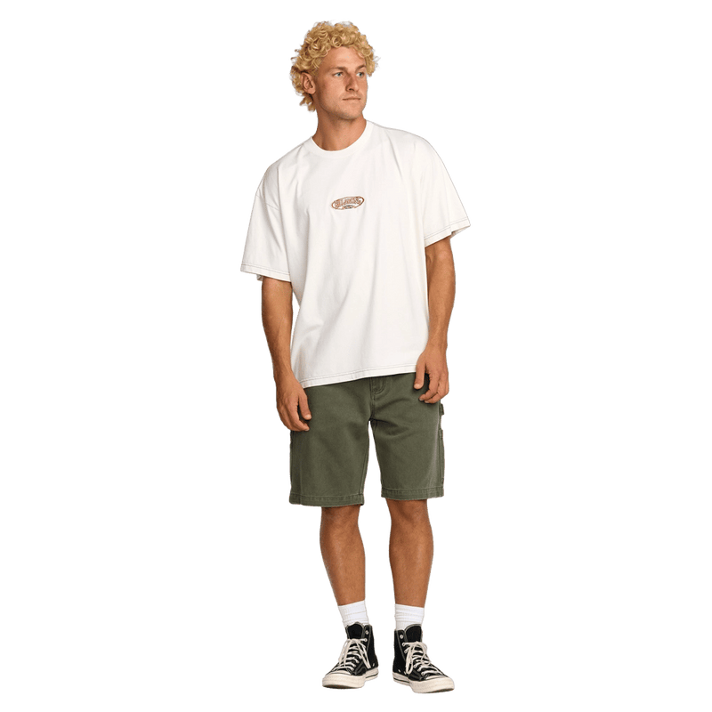 Front view of a man wearing the Bad Dog Workwear Shorts from Billabong in Dark Military.