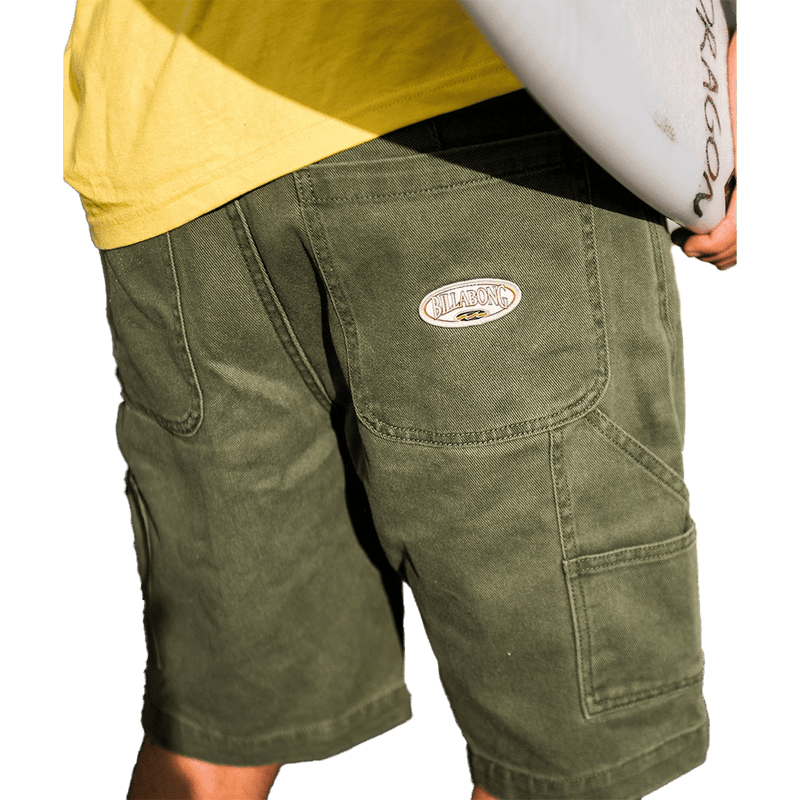 Rear cropped view of a man wearing the Bad Dog Workwear Shorts from Billabong in Dark Military. Featuring back patch pockets with logo and utility pocket on the side.