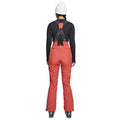 Rear view of women's red Rojo high-rise softshell ski pants with black branded suspenders and slim fit.