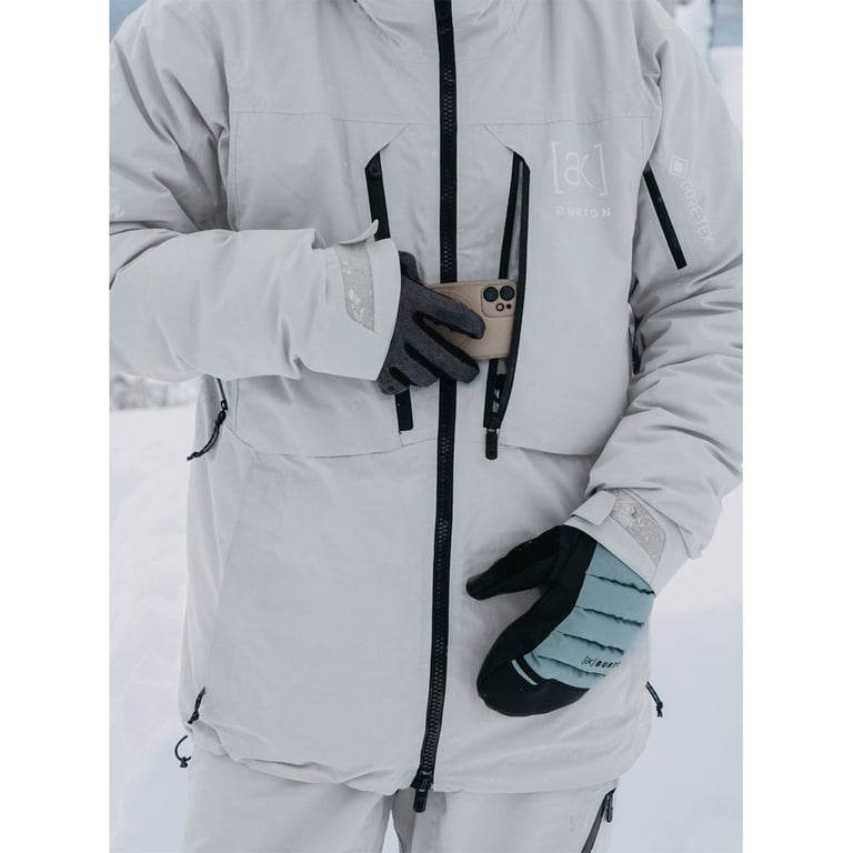 Light grey Burton AK Gore-Tex down snowboard jacket with black waterproof zippers, chest pockets, and sleeve branding.
