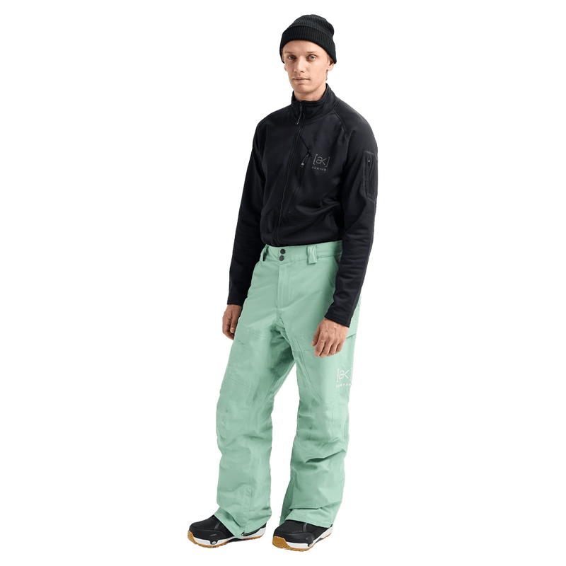 Front full body view of a man wearing the Burton AK Swash Gore-Tex 2L Snowboard Pants in Soft Sage with a blackfleece top and black beanie