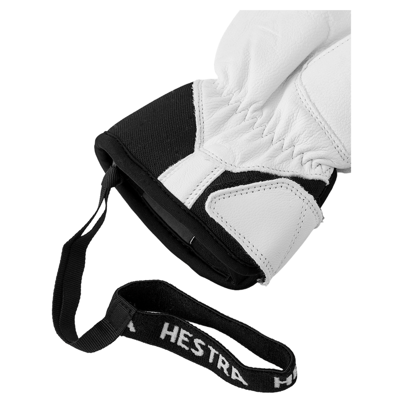 Close-up of white leather Hestra glove cuff with black fabric, elastic wrist, and a black Hestra branded wrist strap.