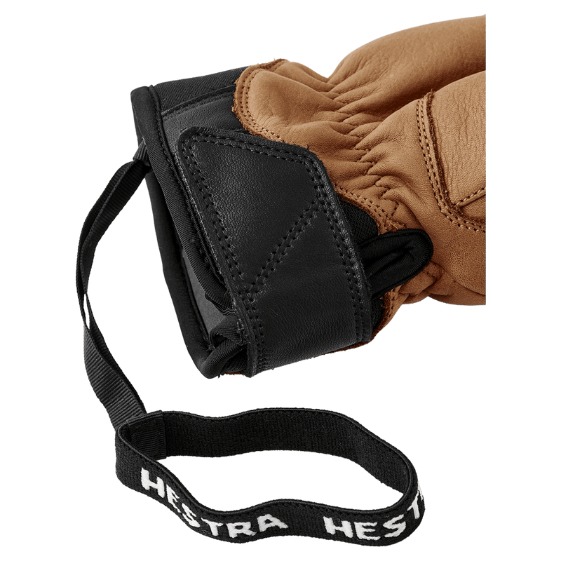 Close-up of tan and black Hestra Leather Fall Line glove cuff with velcro closure and branded elastic wrist leash in colour Cork.