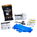 Contents laid our of the Adventure Medical Kits Trauma Pak 1 showing blue plastic gloves, scissors, instructional card, trauma dressing.