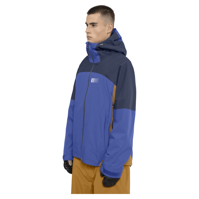 Side view of the Armade Ansel 2L Shell Jacket in Dazzler, Navy and Golden Brown colourway, unisex's model