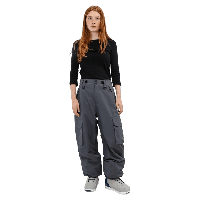 Front view of grey Beyond Medals Cargo 2L Snowboard Pants with large side pockets and a baggy fit on a model.