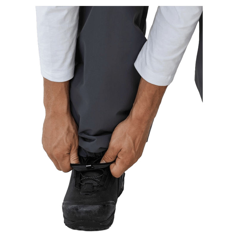 Hands adjusting the elasticated boot gaiter of grey Beyond Medals Cargo 2L Snowboard Pants over a black boot.