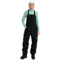 Women's black Burton Reserve Bib Snowboard Pants with front zipper, chest pocket, and white logo on the left leg.