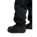 Black Burton Reserve Bib Snowboard Pants hem with adjustable snap cuff over black snowboard boots.