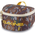 Dakine Goggle Stash travel case with earth-tone abstract pattern, yellow logo, top handle, and dual zipper closure.