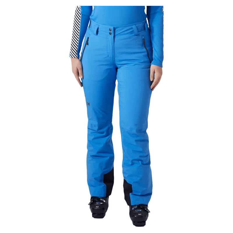 Bright blue Helly Hansen Legendary Insulated Ski Pants for women with zippered pockets and reinforced ankle patches.