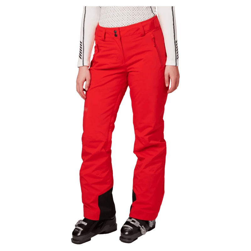 Women's red Helly Hansen Legendary insulated ski pants with front zip, side pockets, and black scuff guards.
