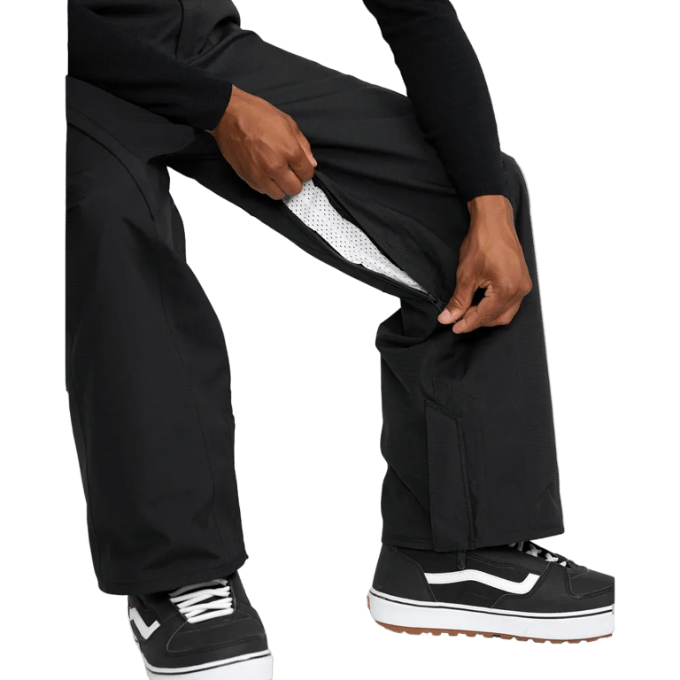 Black Volcom Kleveland snowboard pants showing a zippered inner thigh vent with white mesh lining.