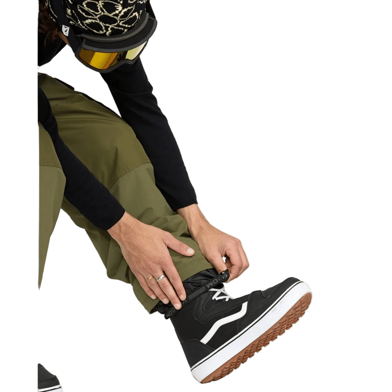 Olive green Volcom Longo Gore-Tex snowboard pants with adjustable elastic ankle gaiters over black high-top boots.