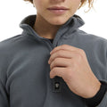 Close-up of a child's hand adjusting the zipper on a grey Elude Microfleece 1/4 Zip Top with a high collar.