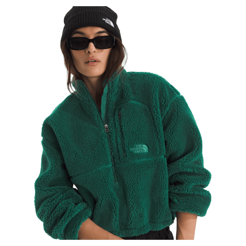 View of a woman wearing The North Face Extreme Pile 2 Pullover for Women in Hunter Green featuring a zip chest pocket, and a small side embroidered logo on the left chest.