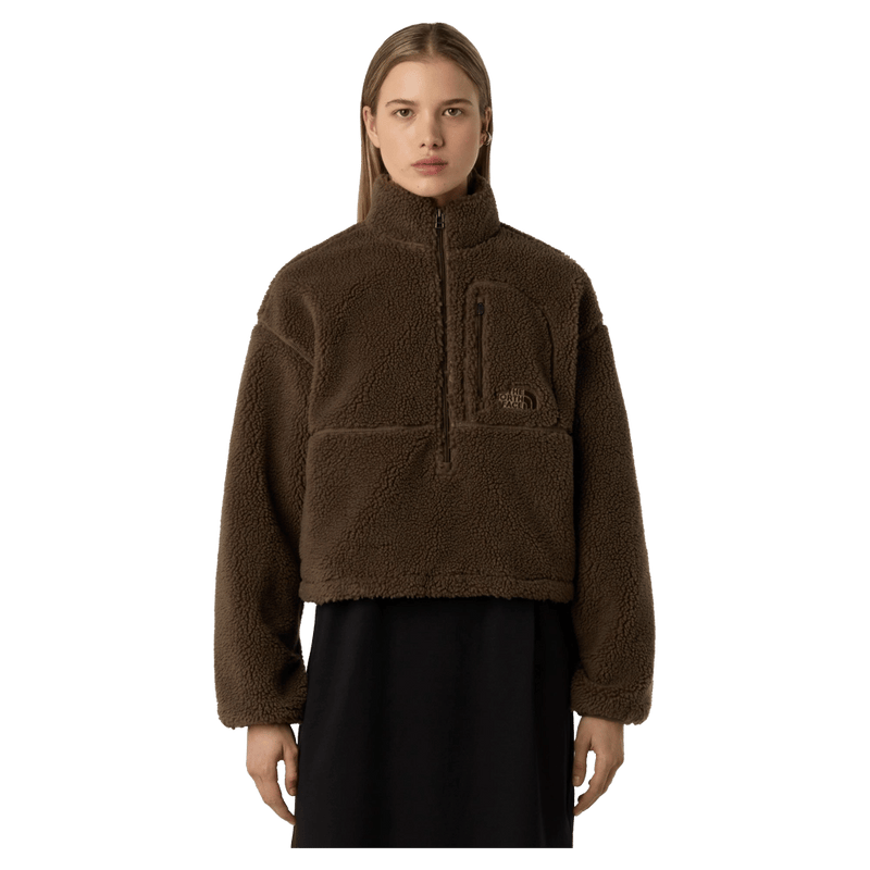 View of a woman wearing The North Face Extreme Pile 2 Pullover for Women in Smokey Brown featuring a half front zip, zip chest pocket, side pockets and adjustable hem, with a small side embroidered logo on the left chest.