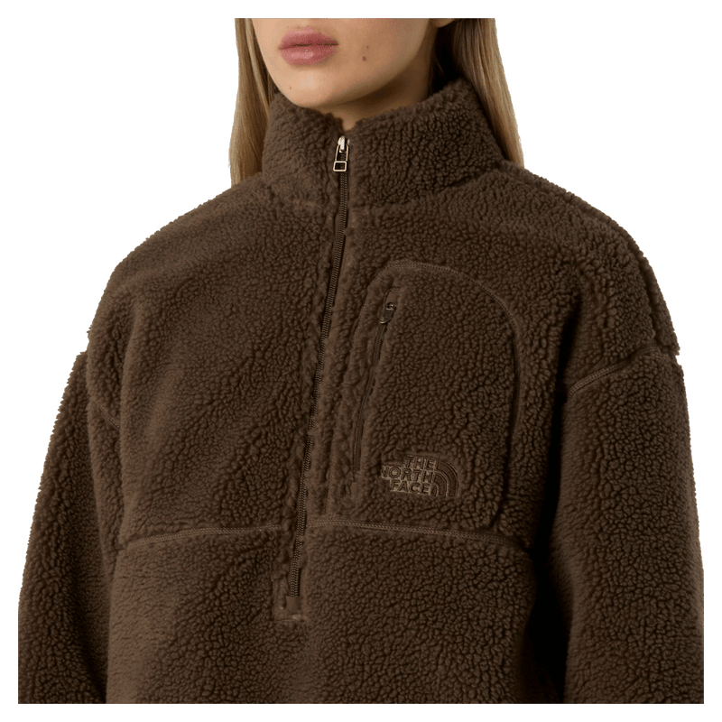 View of a woman wearing The North Face Extreme Pile 2 Pullover for Women in Smokey Brown featuring a zip chest pocket, and a small side embroidered logo on the left chest.