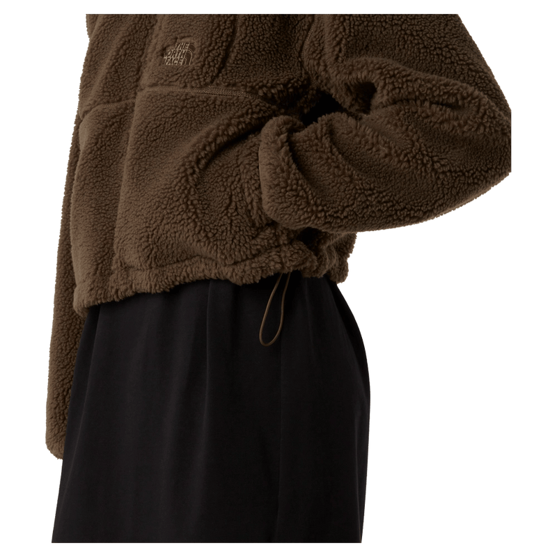 View of a woman wearing The North Face Extreme Pile 2 Pullover for Women in Smokey Brown featuring side pockets and an adjustable hem