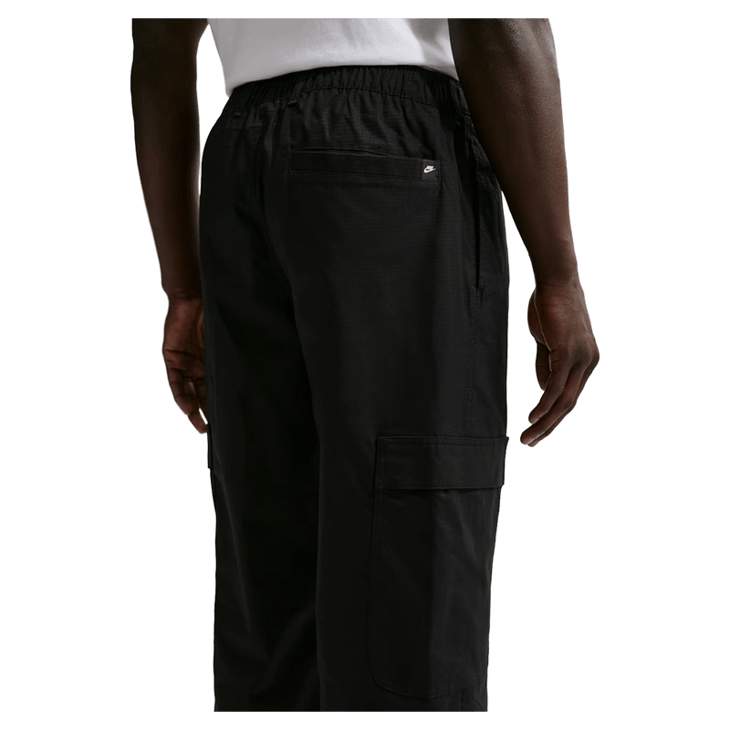 Back view of the Nike Club Cargo Pants in Black colourway, unisex model