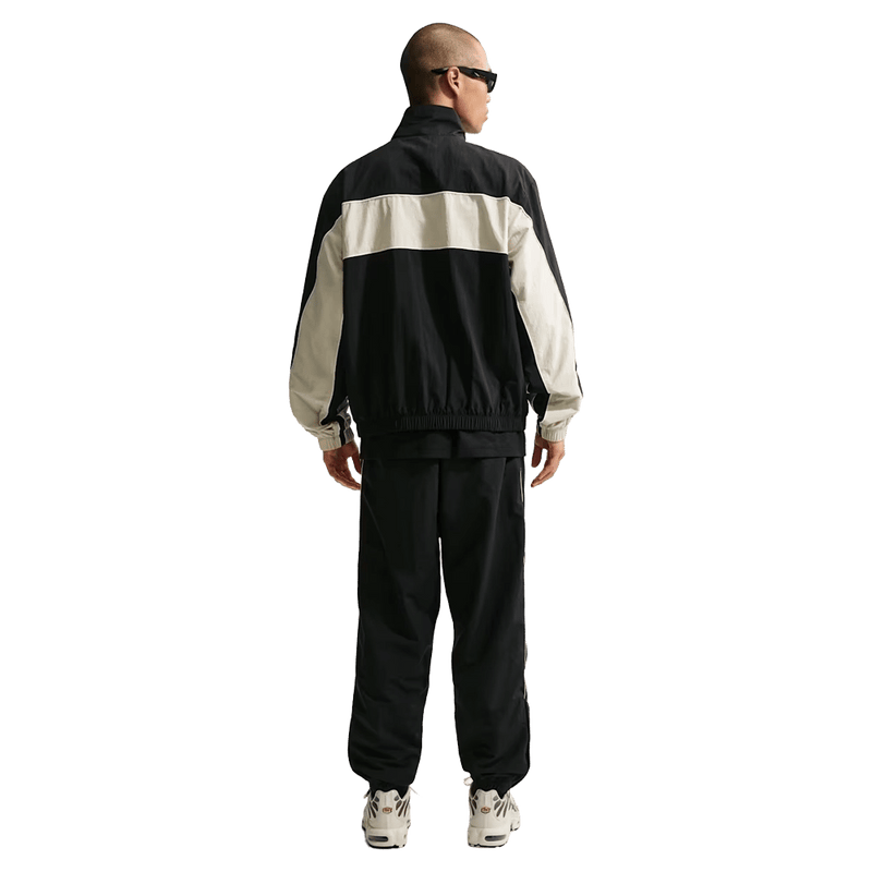Back view of the Nike Club Lightweight Pants in Black and Khaki colourway, men model