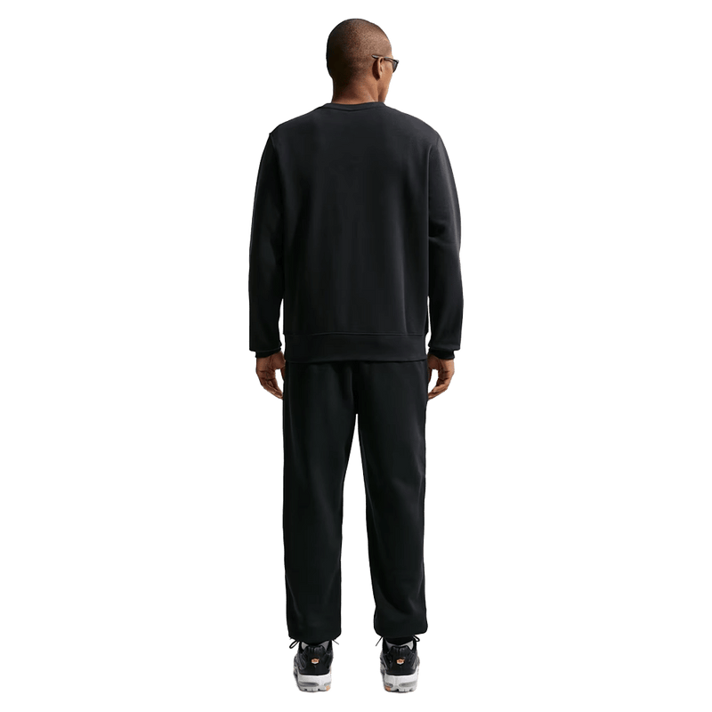 Back view of the Nike Club Track Pants in Black and White colourway, unisex model