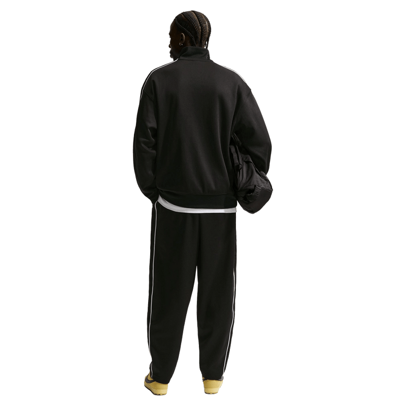 Back view of the Nike Club Track Sweatpants in Black and White colourway, men model