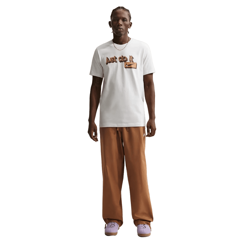 Front view of the Nike Club Pants in Ale Brown colourway, unisex model