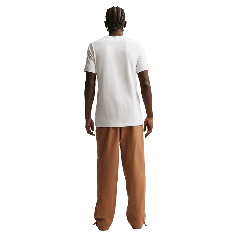 Back view of the Nike Club Pants in Ale Brown colourway, unisex model