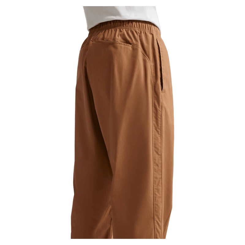 Detail view of the Nike Club Pants in Ale Brown colourway, unisex model