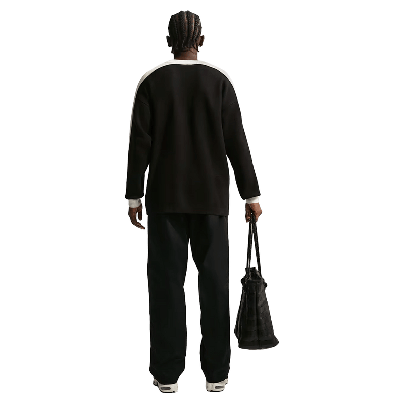 Back view of the Nike Club Pants in Black colourway, unisex model