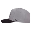 Side view of the Nike Rise Cap in Smoke Grey colourway, unisex model