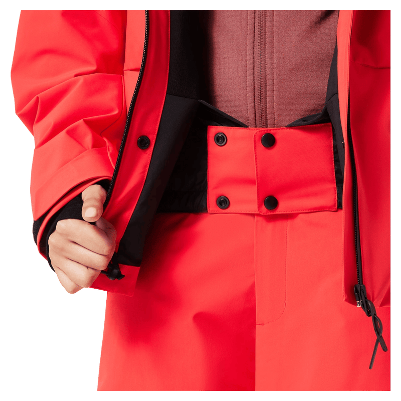 Powder skirt view of the Oakley Canopy Insulated Jacket in HIBISCUS RED colourway, women model