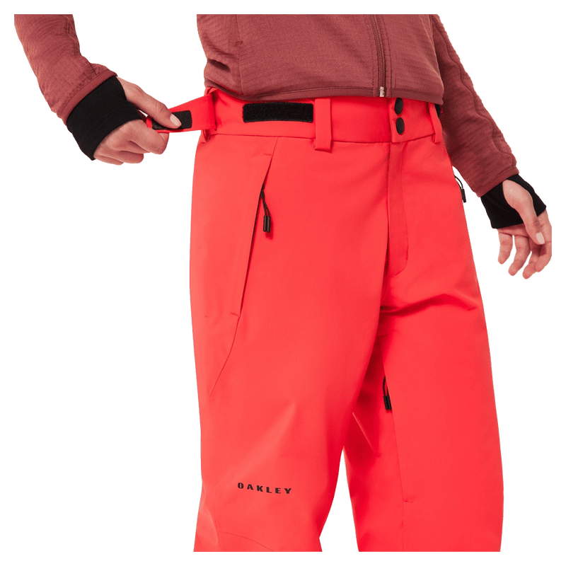 Detail view of the Oakley Canopy Insulated Ski Pants in HIBISCUS RED colourway, women model