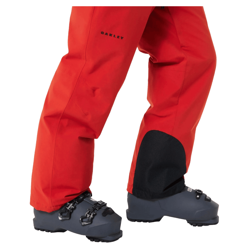 Detail view of the Oakley Canopy Insulated Ski Pants in HIBISCUS RED colourway, men's model