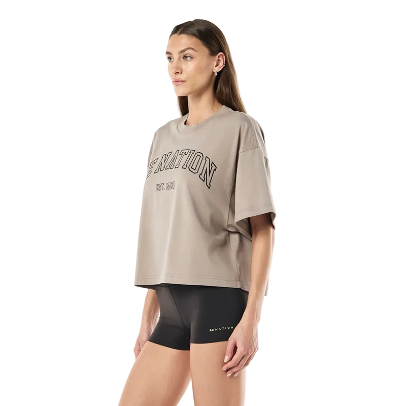 Side view of the P.E Nation Area Tee in Oatmeal colourway, women's model