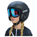 Matte black Poc Skull Dura Jr kids ski helmet with blue mirrored goggles worn by a child with blonde braids.