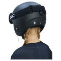 Rear view of a child with blonde braids wearing a matte black Poc Skull Dura Jr kids' ski helmet with black goggles.