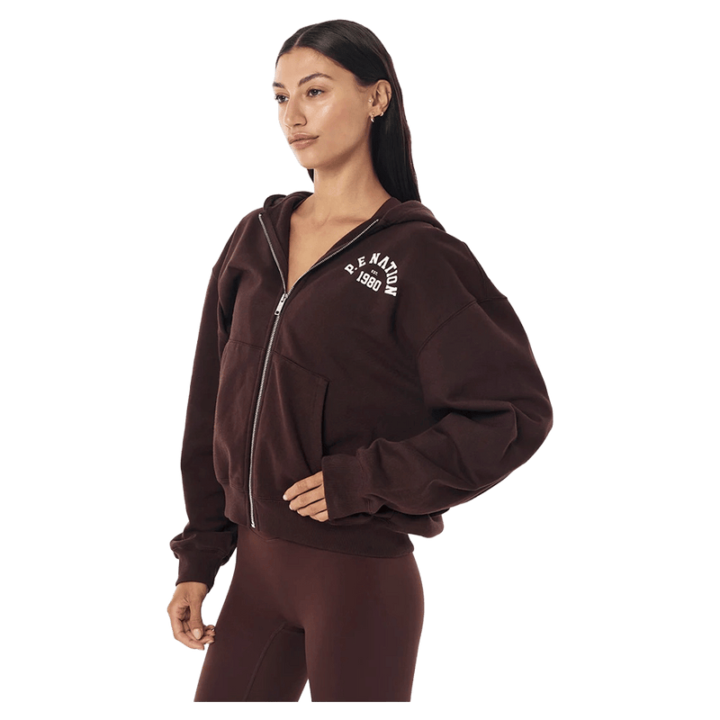 Side view of the PE NATION Established Zip Thru Hoodie Mahogany Jumper,  26/27 Womens's model