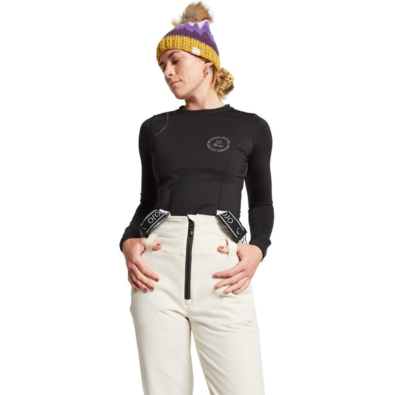 Rojo women's white high rise softshell ski pants with black suspenders and front zipper.
