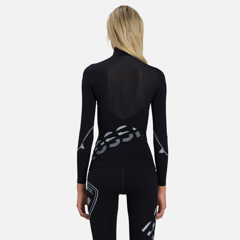 Back view of tight-fit black Rossignol Infini Compression Race Top with high neck and grey graphic details on the sleeves. Shown on model